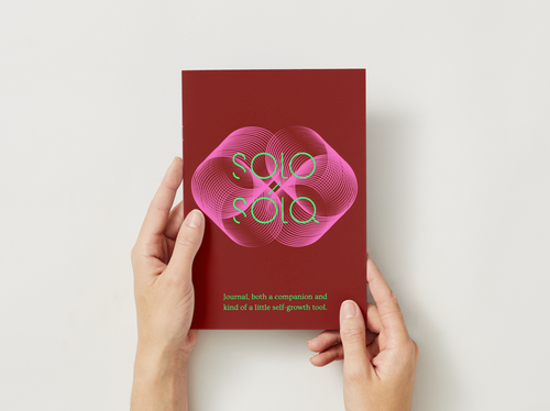 Red book titled 'SOLO & SOLO' held by hands on a white background
