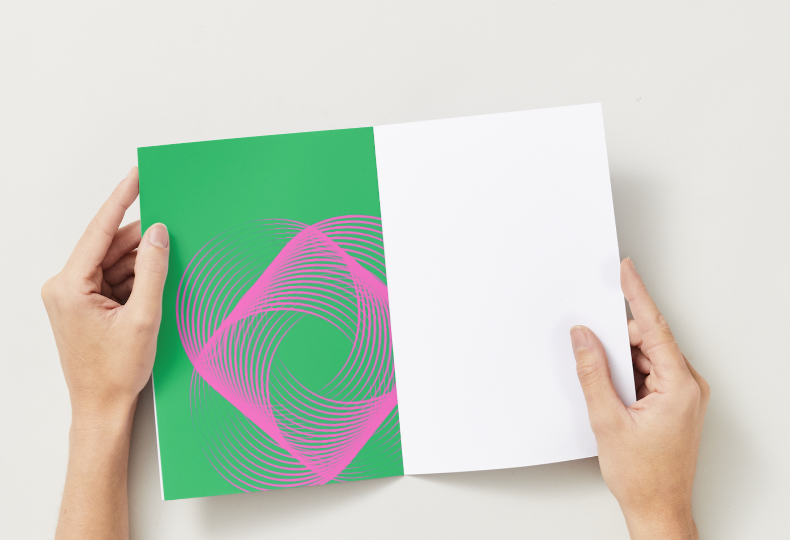 Two hands holding a green and white card with a pink and purple design on a light gray background